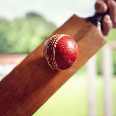 Cricket Batsman Hitting A Ball Shot From Below With Stumps On Cricket Pitch